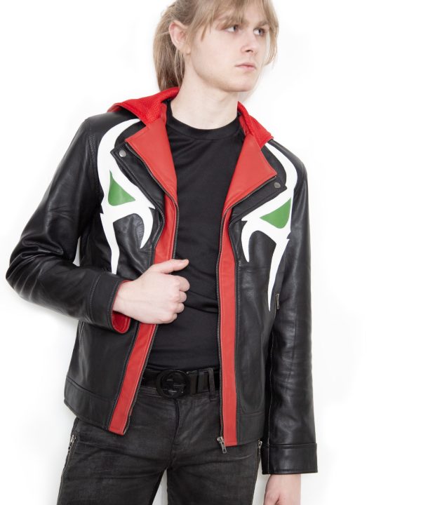 (Front): Photo of a model wearing a black leather jacket. The jacket is a motorcycle cut with a red hood and a red leather lining that is visible inside the cuffs and the folded down collar. There is also a strip of red leather either side of the front zipper. Where breast pockets typically would be on a jacket, there are [handpainted/patched] green eyes surrounded by white details. The collar has metal pop buttons to hold it in place. (Back): Photo of the same black leather jacket with a red hood. The jacket is a motorcycle cut. The inside of the hood has a mesh lining.